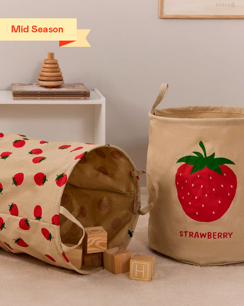 Barnrum med tygkorg och lektunnel med jordgubbar. Etikett: “Mid Season”.