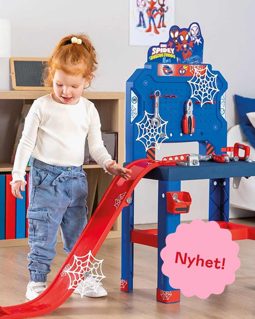 Barn leker med dockhus på bord. Rosa etikett med texten 'Nyhet!'.