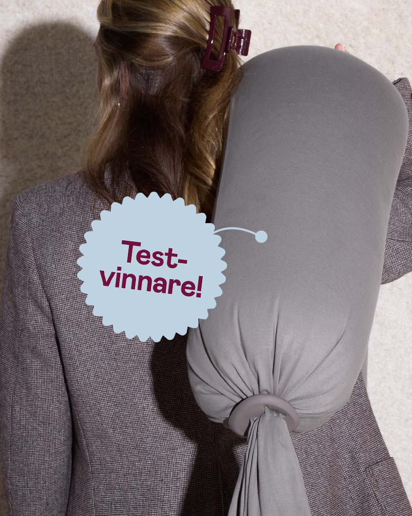 Kvinna med grå gravid- och amningskudde, med texten 'Bäst i test'.